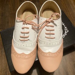 Pink and white flat Oxford style or saddle shoe.